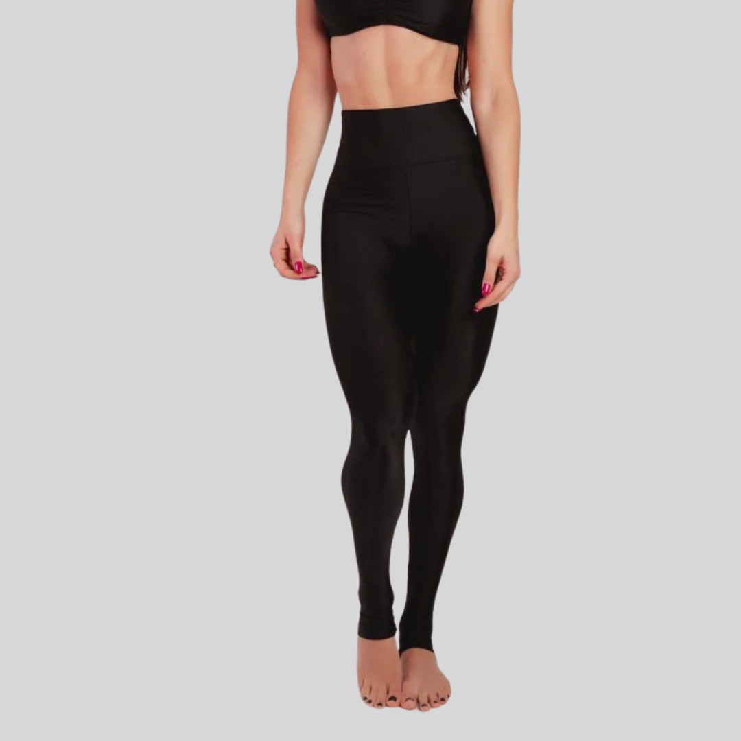 Person wearing black leggings on a plain background