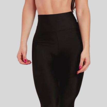 Black high-waisted leggings worn by a person on a light gray background